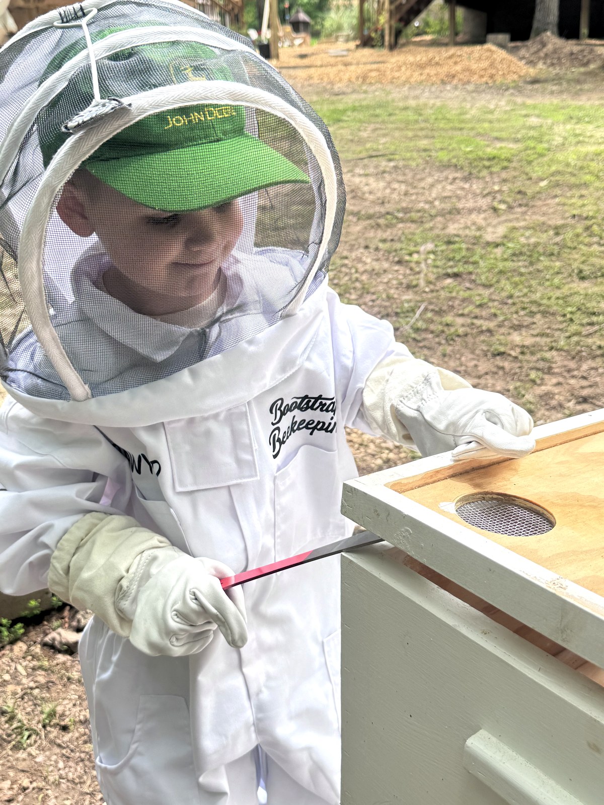 Sawyer holding hive tool at the feeder box